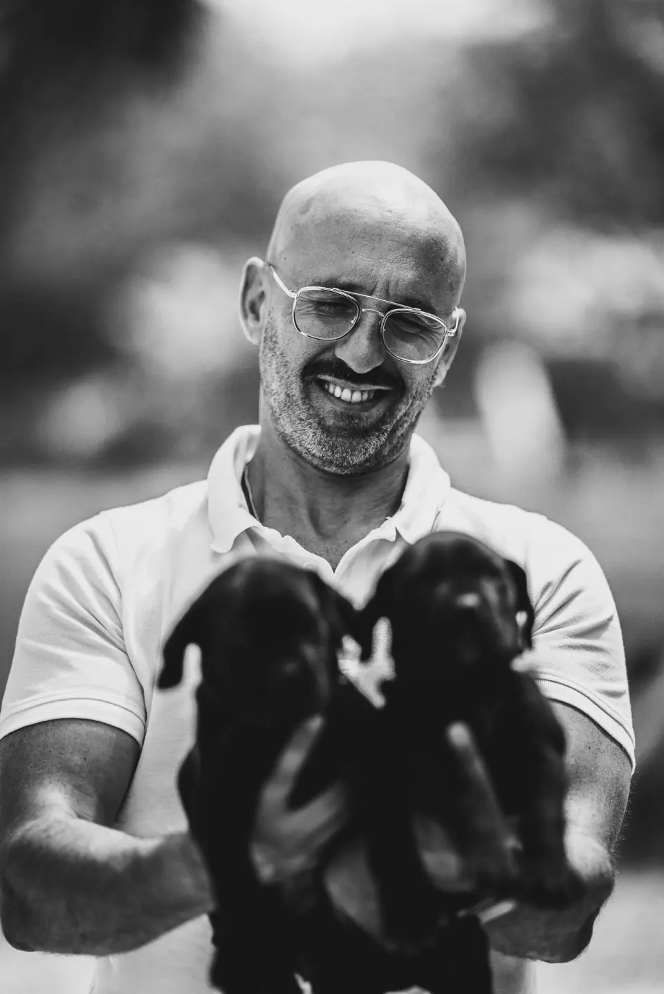 Rui Navarro segurando dois filhotes de Boerboel pretos